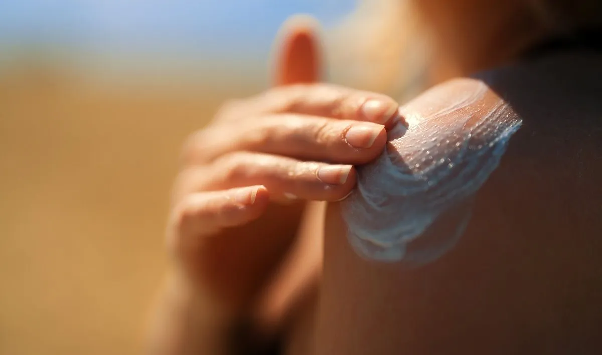 Sun cream being applied to a shoulder