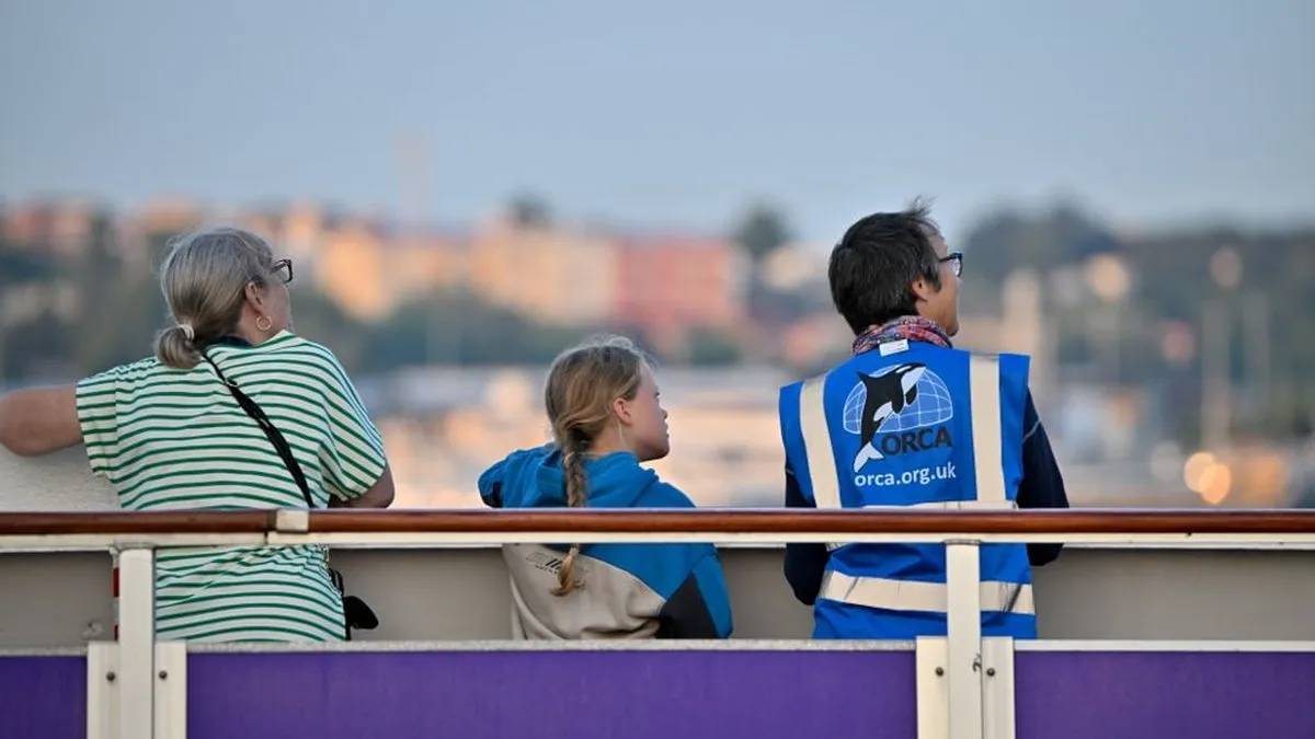 People on a ship look out over the water, one is an ORCA representative