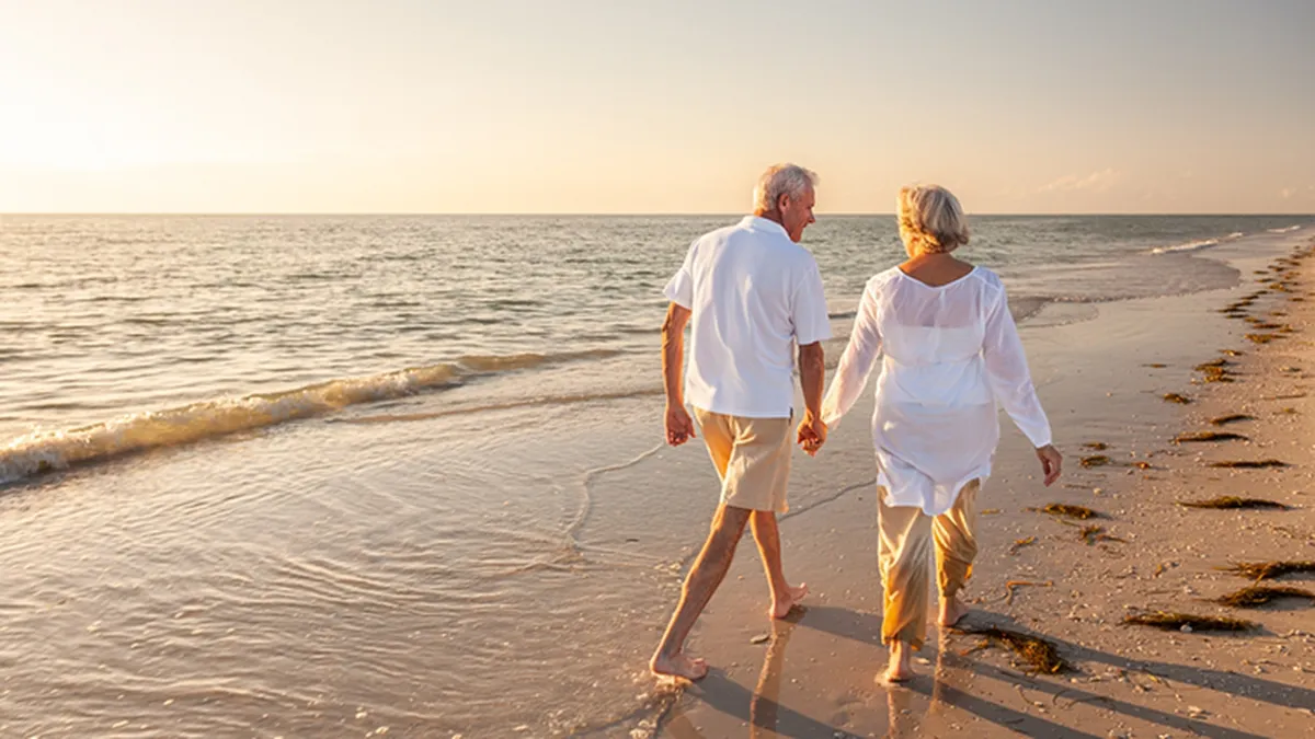 Couple holding hands and walking on a beach