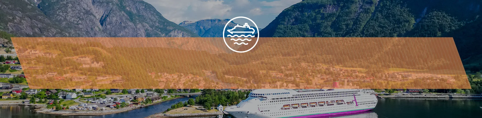 Ambience docked in a scenic fjord, surrounded by green mountains and a small town under a partly cloudy sky.