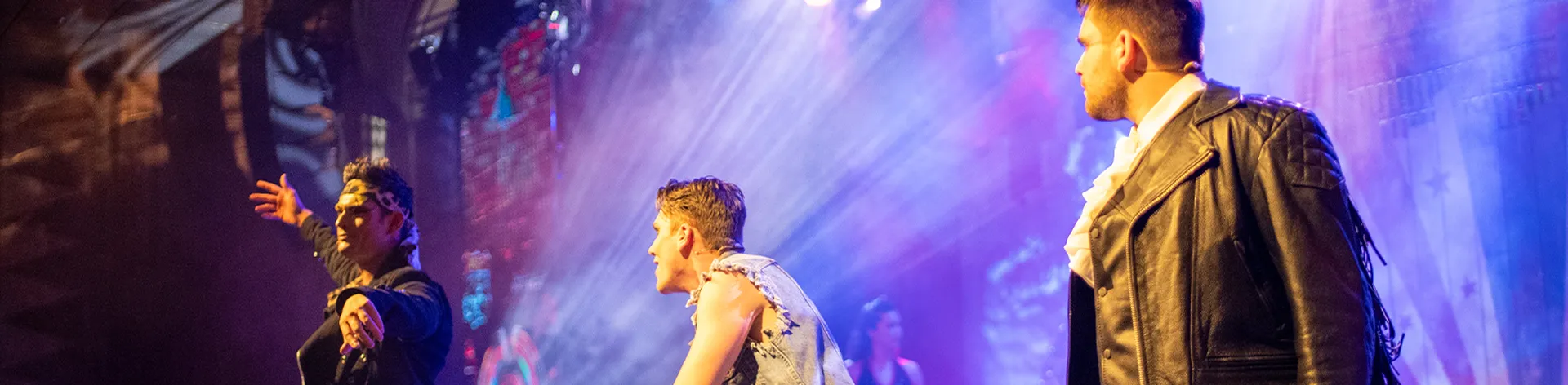 Performers on stage under lights in a dynamic setting.
