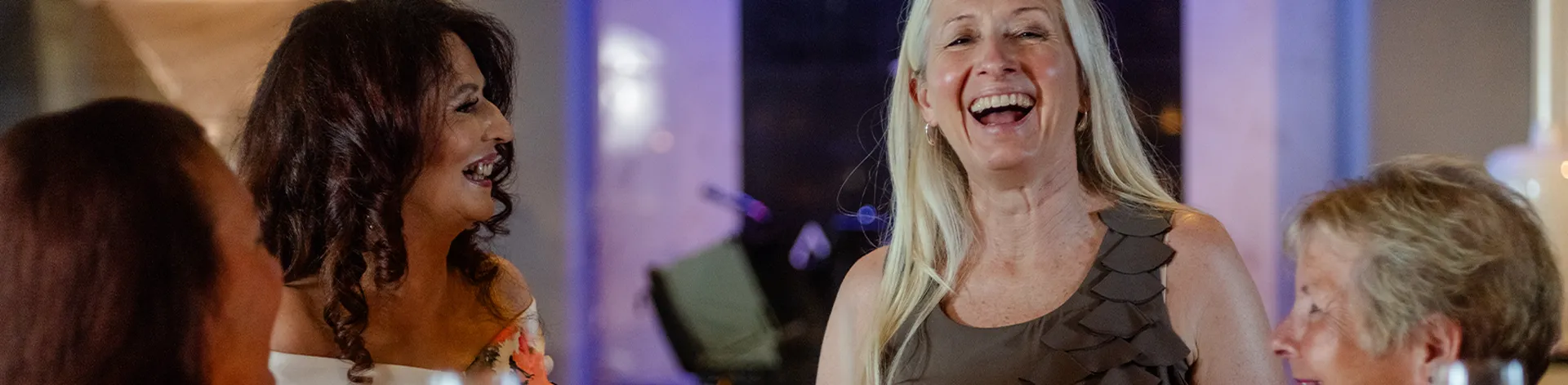 A group of women laughing and enjoying a conversation in Raffles Bar
