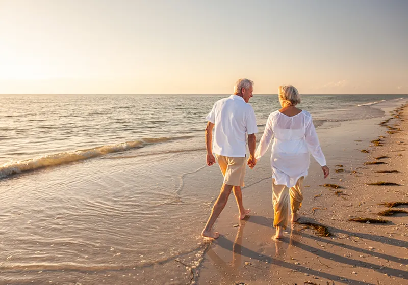 Couple holding hands and walking on a beach