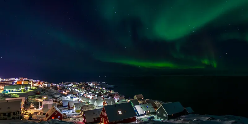 Northern lights over a village at night in Norway