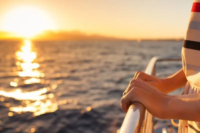 Person holding onto rails on ship