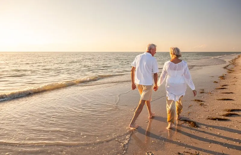Couple holding hands and walking on a beach