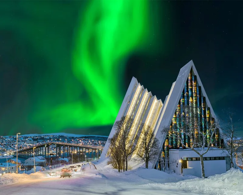 Stunning northern lights over the, snow-covered Eismeerkathedrale in Tromso, Norway