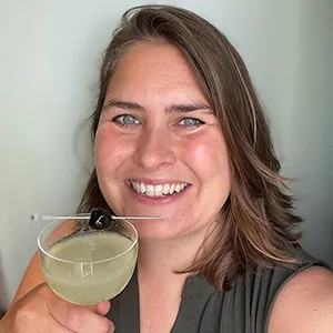 Sarah Miller holding a cocktail with a cherry garnish