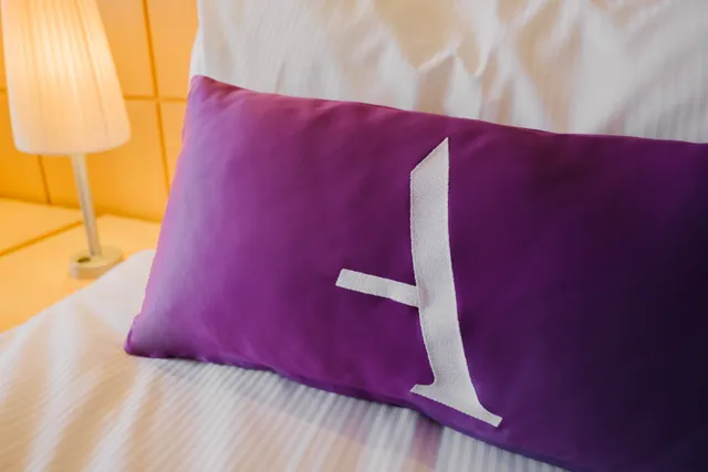 Close-up of an Ambassador Cruise line pillow on a bed