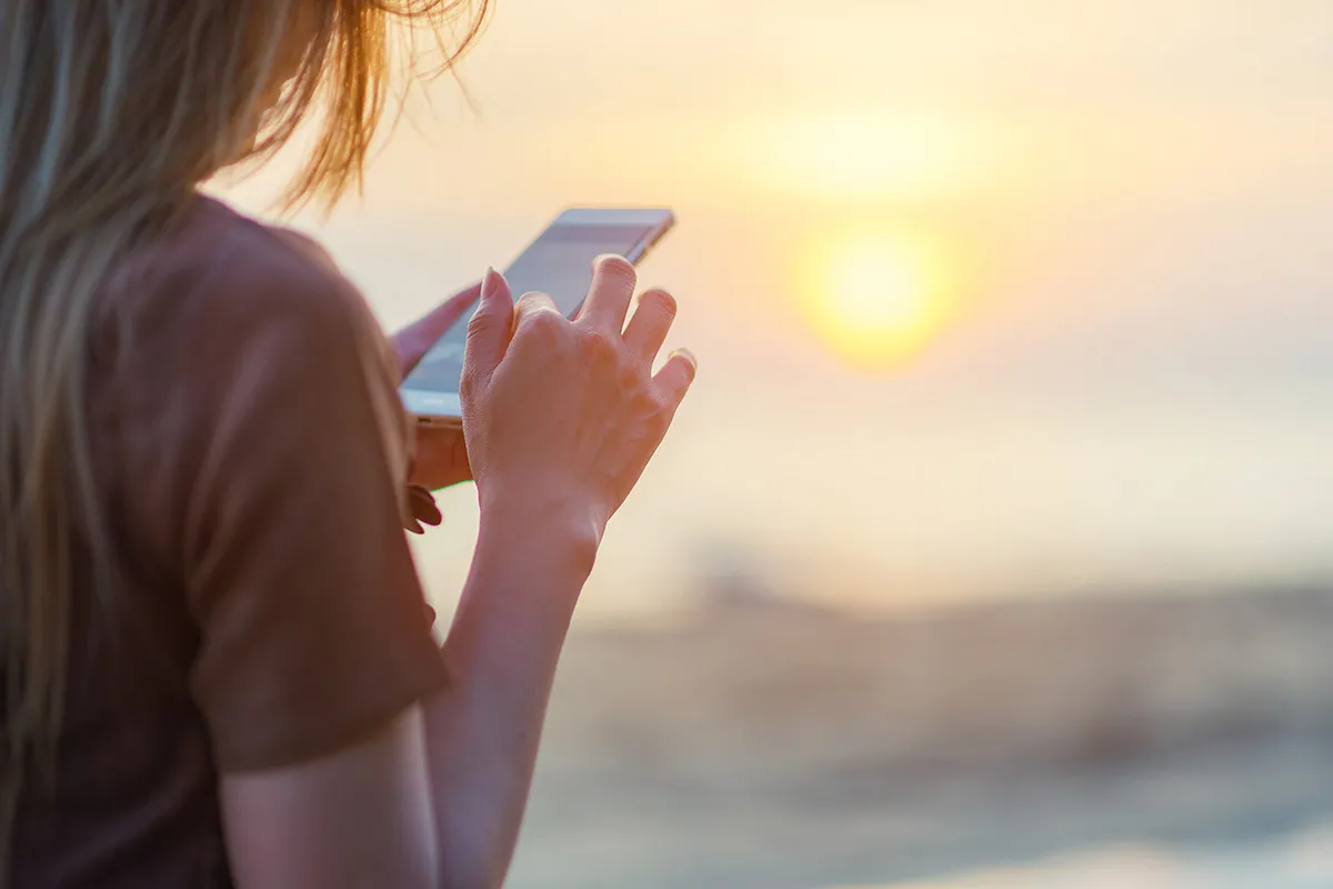 Women using app on the beach on holiday