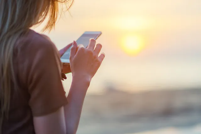 Women using app on the beach on holiday