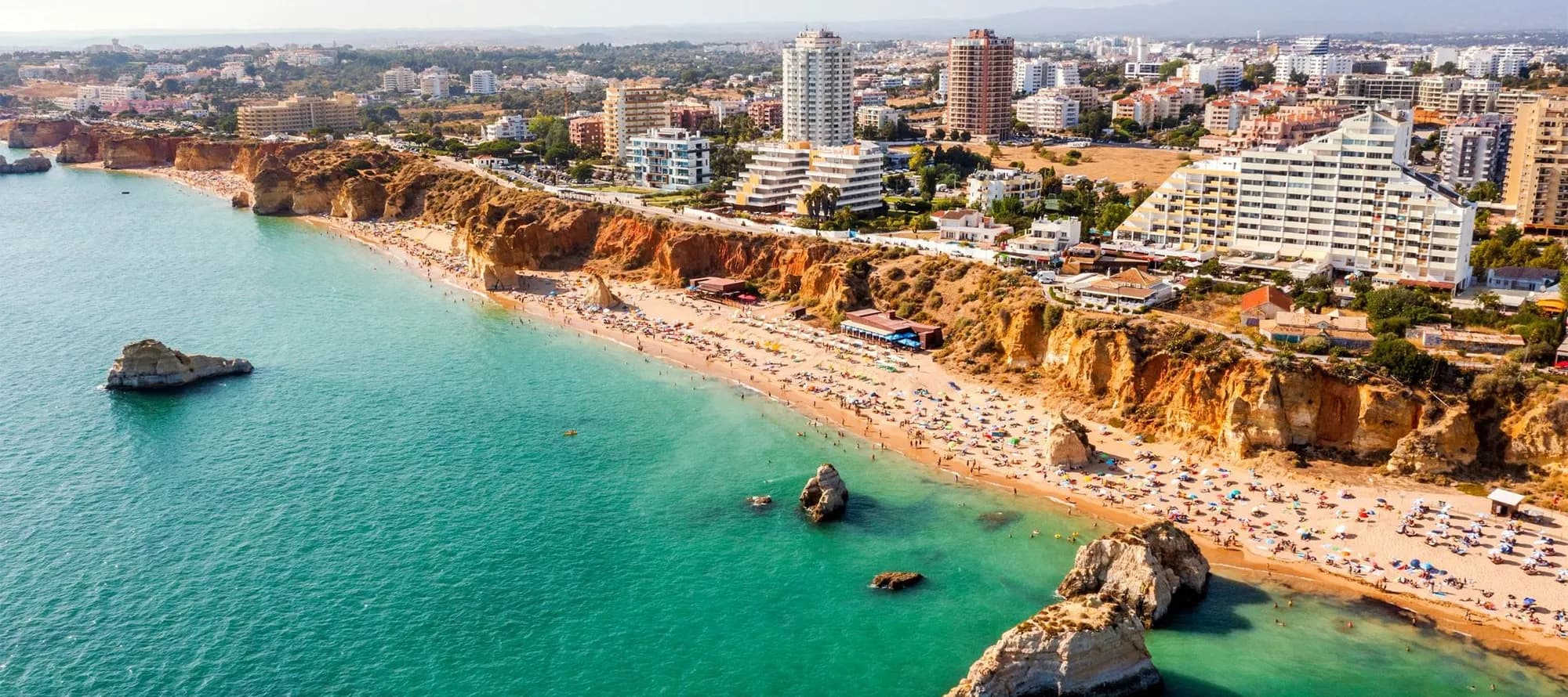 Aerial view of touristic Portimao with wide sandy Rocha beach, Algarve, Portugal