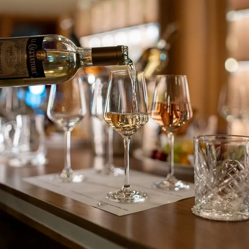 White wine being poured into a glass on a table