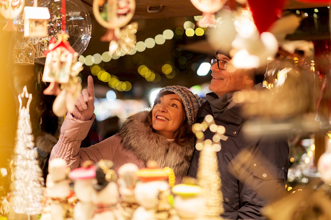 Couple at a festive market shopping for ornaments
